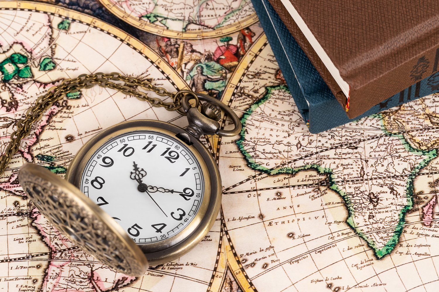 Vintage pocket watch clock on ancient map background with books