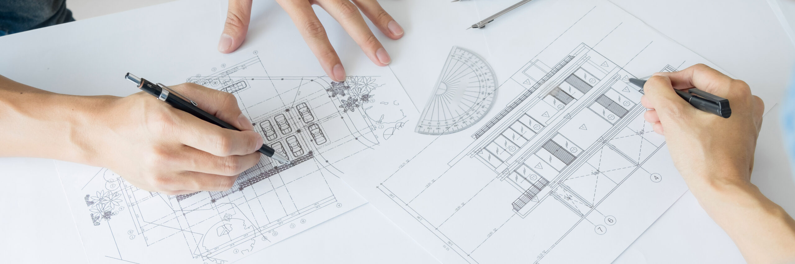Architects engineer discussing at the table with blueprint closeup on hands and project print, team group on construciton site check documents and business workflow