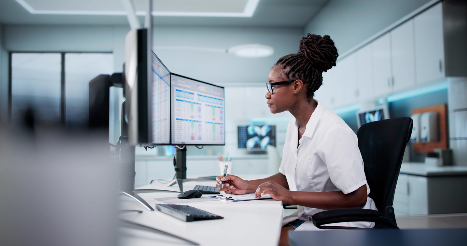 Hospital doctor using spreadsheet for billing codes on desktop