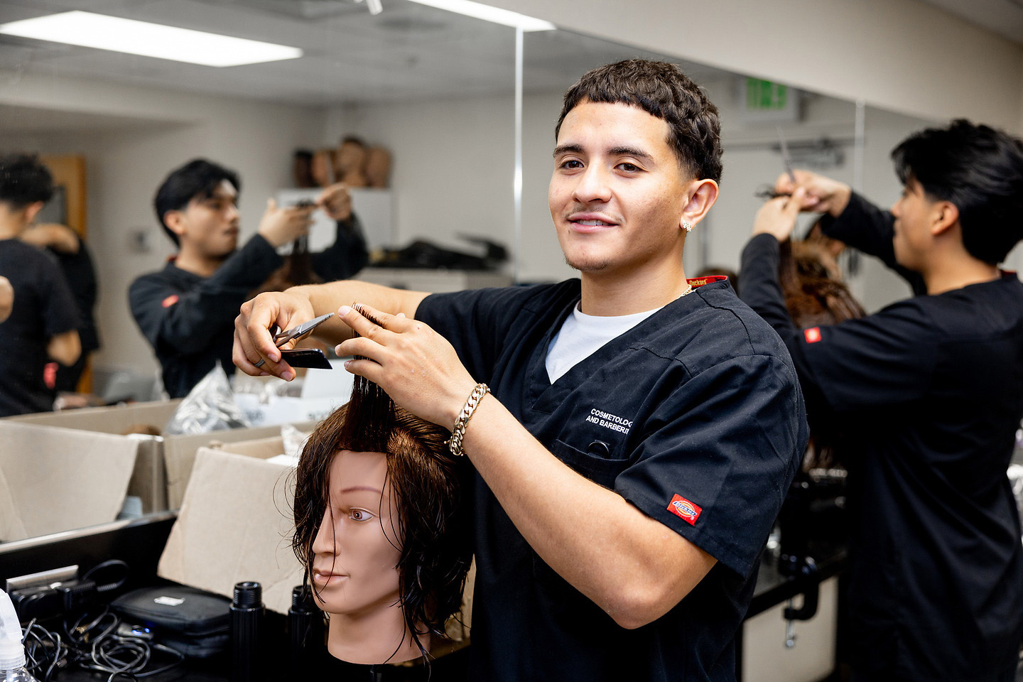 Barbering student cutting a live client in the barbering lab
