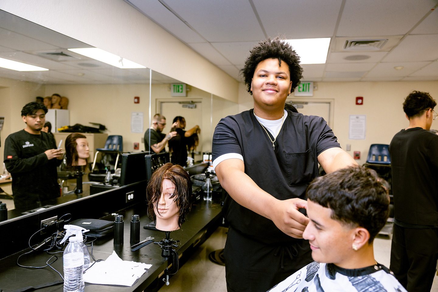 Barber and smiling client with barbering cape